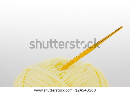 Yellow ball of wool and knitting needles isolated on white background