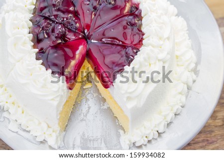 A cut of  Berries cake with Blueberry topping