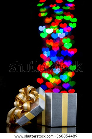 Defocused bokeh lights heart shaped are moving out of open gift box