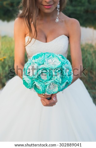 Beautiful bride holding a delicate bouquet of flowers