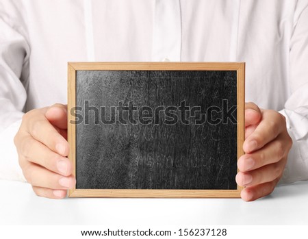 holding blank chalkboard in hand