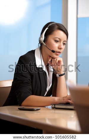 Beautiful business service woman sitting at table looking at computer