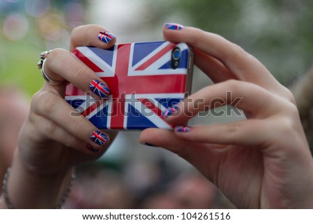LONDON - JUNE 3: A camera phone is lifted above the crowds to capture a photo as crowds celebrate Thames Diamond Jubilee Pageant on June 3, 2012 in London.