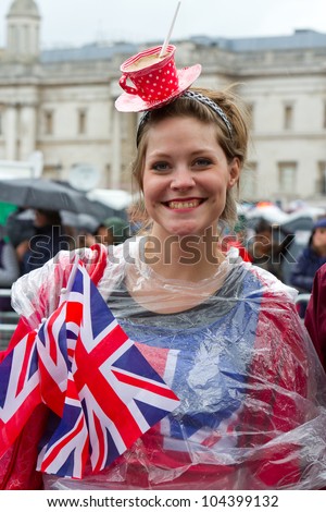 LONDON - JUNE 5: An unidentified woman wearing a cup of tea hat celebrates Diamond Jubilee celebrations at Trafalgar Square on June 5, 2012 in London.
