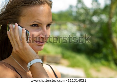 Portrait young pretty girl using mobile phone background summer park