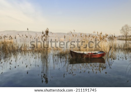 A boat in the peaceful lake. Like the time an nature stand still, just for taking photo.