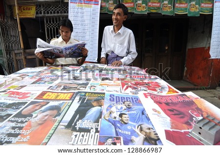 YANGON, MYANMAR - JANUARY 30 : Unidentified men are selling sport newspaper on the street in Yangon, Myanmar, January 30, 2010. Yangon is a former capital of Myanmar and the capital of Yangon Region.