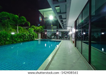 Modern house with swimming pool at night