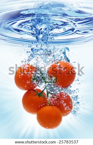 A tomato splashing into water against a white background.