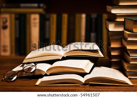 opened book, lying on the bookshelf with a glasses