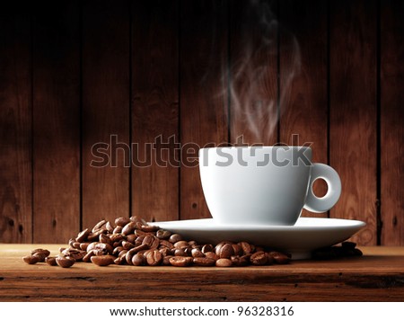 Cup of coffee with coffee beans on a beautiful brown background.