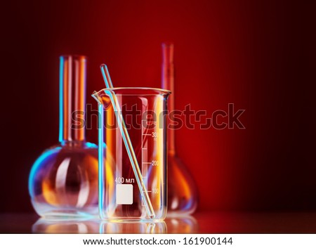 Laboratory glassware on color background