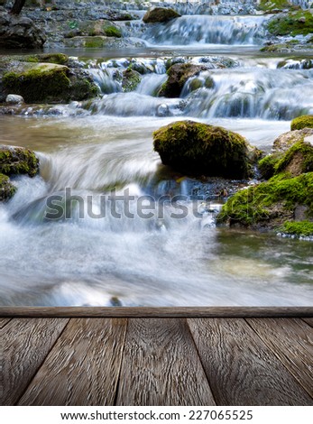 The beautiful waterfall in forest and wood pier, spring, long exposure