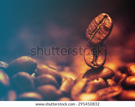 Closeup of coffee beans with focus on one.Filtered image: cool cross processed vintage effect.