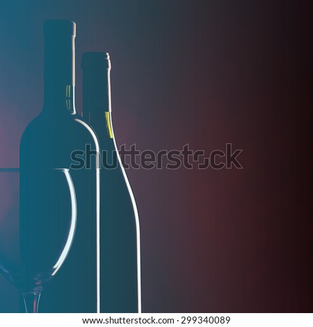 Bottle and glass of red wine on dark red background. Filtered image: vintage effect.