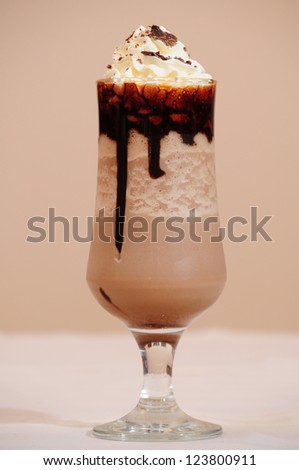 Glass of coffee cocktail isolated on beige background