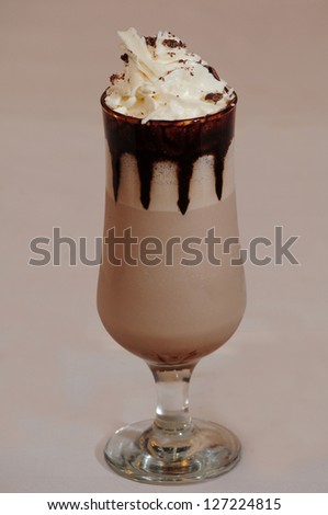 Glass of coffee cocktail isolated on beige background