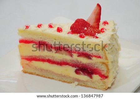 A wedge of vanilla cake with strawberries and bananas