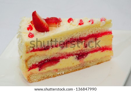 A wedge of vanilla cake with strawberries and bananas