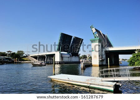 A sailing boat passing under the open drawbridge, West Palm Beach, FL, USA