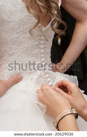 Female hands tightening a corset to the bride