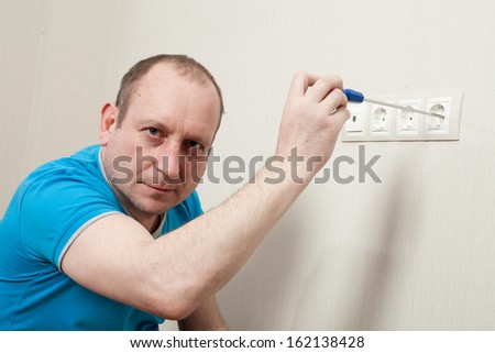 The master repairs the room in the apartment.