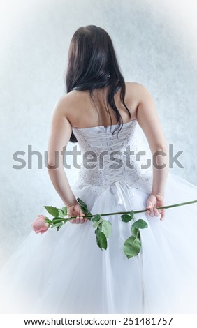 the bride puts on a white dress, a view from a back.