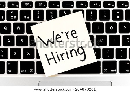 We\'re hiring note over keyboard notebook, laptop. Job concept.