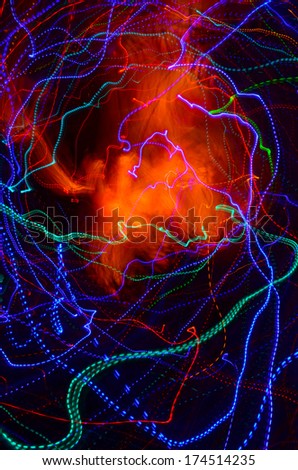 Abstract blue, green and purple neon lines and an orange nebulosity on a black background