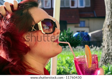 The woman in a sun-glasses, sitting in his Garden, rest, drink cocktails.              ?