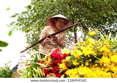 HANOI, VIETNAM - APRIL 21: Unidentified flower vendor at the flower small market on April 21, 2012 in Hanoi, Vietnam. This is a small market for retail florists and street vendors.