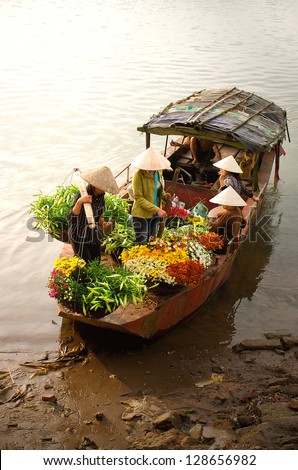 Women selling flowers on a boat in the early morning