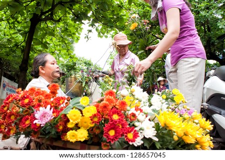 HANOI, VIETNAM - APRIL 21: Unidentified flower vendor at the flower small market on April 21, 2012 in Hanoi, Vietnam. This is a small market for retail florists and street vendors.