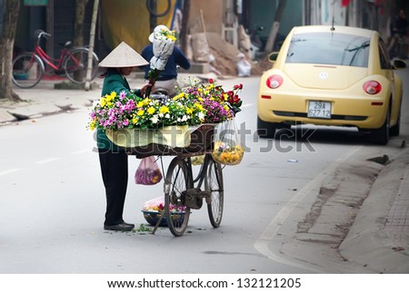 HANOI, VIETNAM - FEBRUARY 24: Unidentified flower vendor at the flower small market on FEBRUARY 24, 2013 in HANOI, VIETNAM. This is a small market for retail florists and street vendors