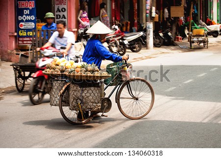 HANOI, VIETNAM - MARCH 23: Unidentified pineapple vendor at the pineapple small market on MARCH 23, 2013 in HANOI, VIETNAM. This is a small market for retail pineapple growers and street vendors.