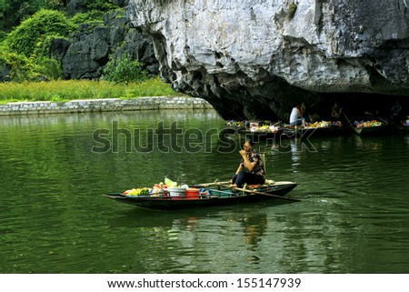 NINHBINH, VIETNAM, MAY 12: Unidentified woman, own her little shop on boat in Tamcoc on May 12, 2013 in Ninhbinh, Vietnam. Tamcoc is a famous place in Ninhbinh province