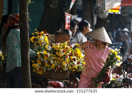 NAMDINH, VIETNAM - SEPTEMBER 18: Unidentified flower vendor at the flower small market on September 18, 2013 in NamDinh, Vietnam. This is a small market for retail florists and street vendors