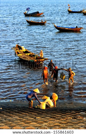 NAM DINH, VIETNAM - AUGUST 27: A lot of fishers sort out their catch on the shore and sell fish to dealers, August 27, 2013, NamDinh, Vietnam