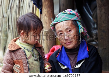 MUCANGCHAI, VIETNAM - OCTOBER 6: Hmong woman and boy name VangALu on October 6, 2013 at Mucangchai, Vietnam. Hmong people are known for their indigo-dyed costumes and ornate silver jewellery.