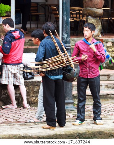 SAPA, VIETNAM-August 31: Hmong men and bamboo trumpets on the streets of Sapa, Vietnam on 31 August 2013. Sapa is home to tourist attractions
