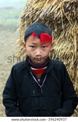 HAGIANG, VIETNAM - FEBRUARY 15:  Aboriginal boy unspecified makeup for him hair red woolen at February 15, 2014 in HAGIANG, VIETNAM. HAGIANG is the northernmost province of Vietnam