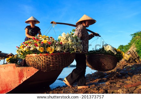 NAMDINH, VIETNAM June 27, 2014: unidentified women selling flowers on a boat in the early morning