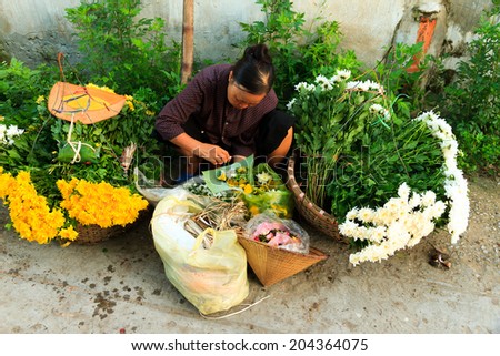 NAMDINH, VIETNAM July 10. 2014 : Unidentified flower vendor at the flower small market in Namdinh, Vietnam. This is a small market for retail florists and street vendors.
