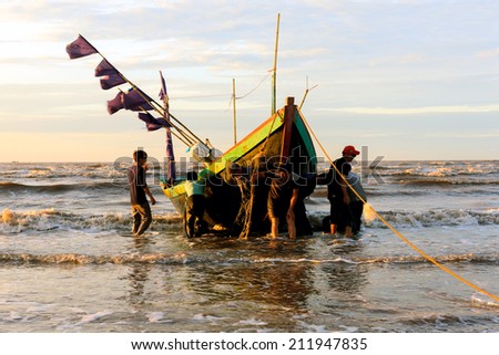 NAMDINH,VIETNAM - AUGUST 10, 2014 . Fishermen fishing in the sea at sunrise in HAILY ,  in HAILY ,This location is very famous for salt production and fisheries.