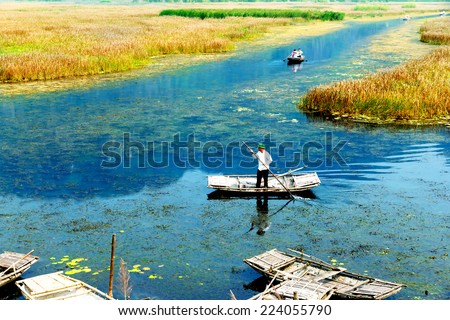NINHBINH, VIETNAM October 11,2014: An unidentified man wearing hat, sailing a boat on Van Long lake, Ninhbinh, Vietnam