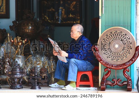 NAMDINH, VIETNAM December 30, 2014: unidentified man sitting reading the newspaper. Reading newspapers is a beautiful culture in Vietnam.