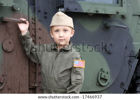 small boy soldier in front of a military truck, youth, young