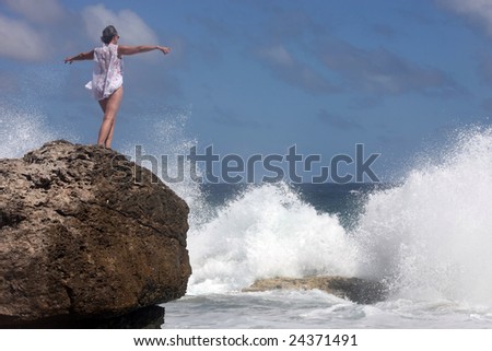 woman with arms out against the ocean wind