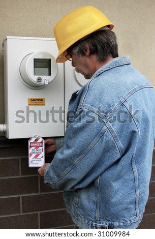 Electrician places a lock out tag on an electrical panel