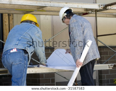 Construction builder and Architect review blue prints at job site